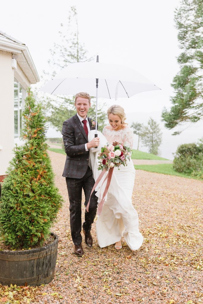 bride and groom with umbrellas on rainy wedding day