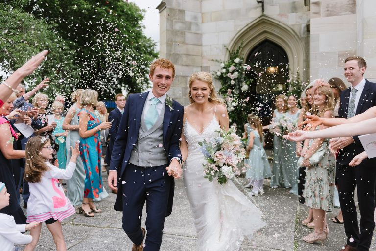 bride and groom walking out of church
